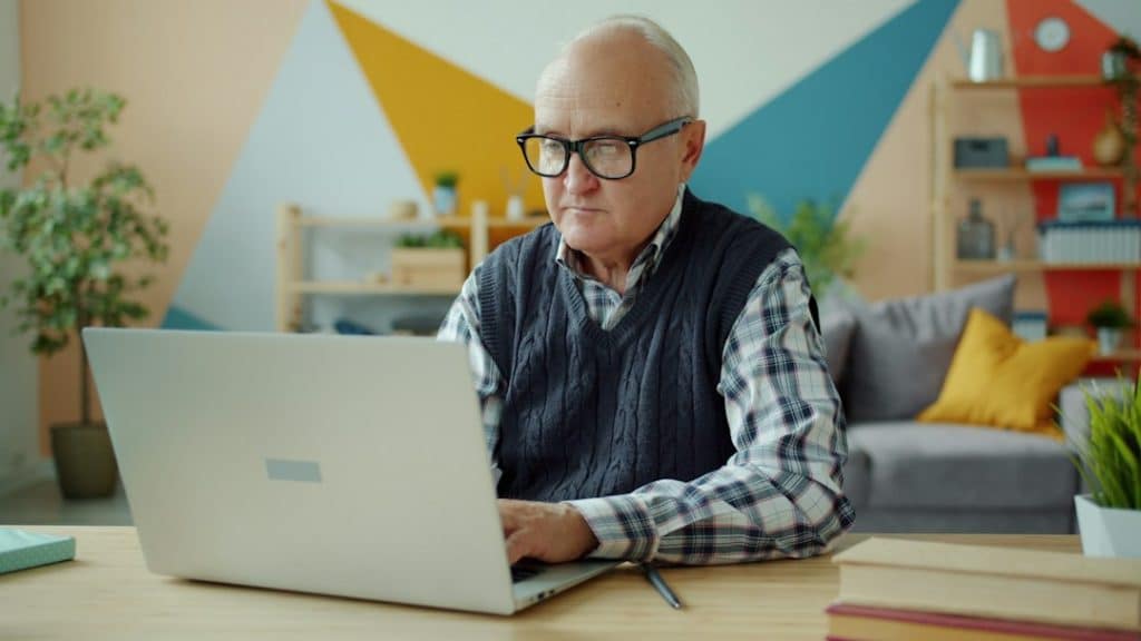 older worker reviewing retirement milestones on a laptop